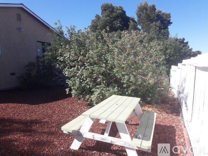 A picnic table is in the middle of a gravel area.