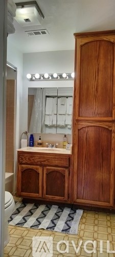 A wooden cabinet with a mirror above it.