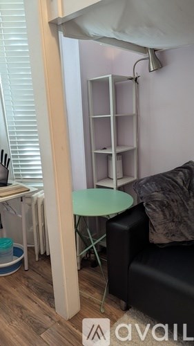 A living room with a black couch and a small table.
