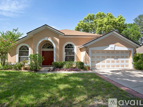 A beige house with a red door and a white garage door.
