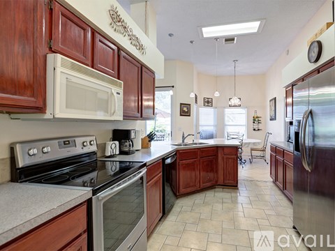 A kitchen with wooden cabinets and a white microwave above the stove.
