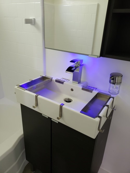 A white and black bathroom sink with a mirror above it.