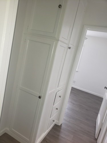 A white door with a black handle is on the left side of the image.