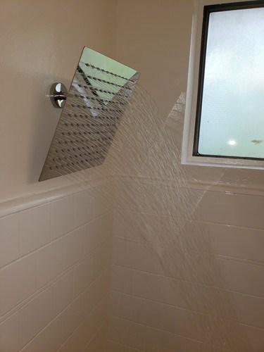 A bathroom with a mirror and a tiled wall.