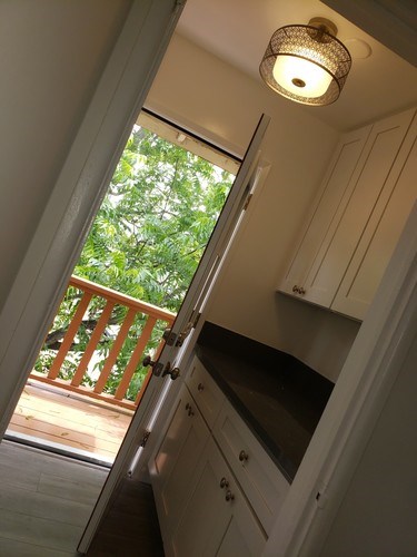 A kitchen with a refrigerator and wooden cabinets.