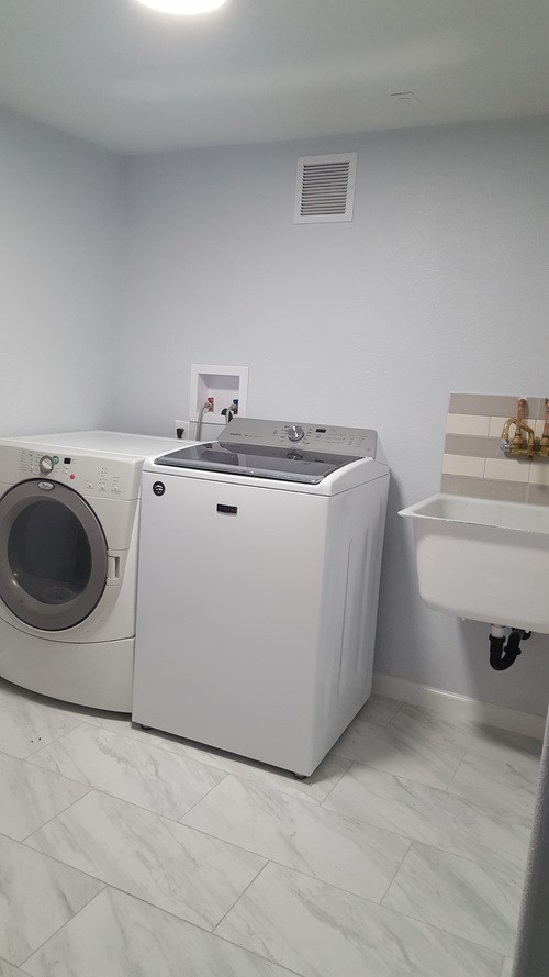 A white washing machine and dryer in a laundry room.