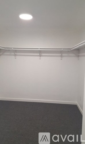 A white wall with a long white pipe and a light on it.