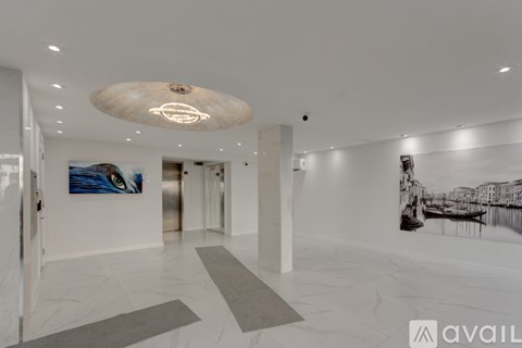 A spacious hallway with a marble floor and a ceiling light fixture.