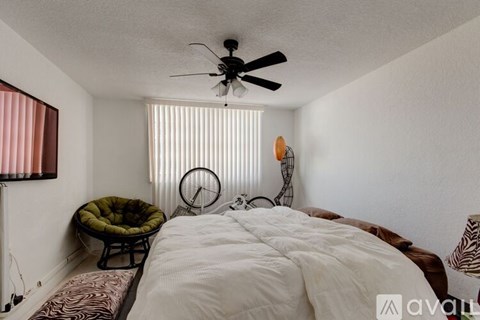 A bedroom with a large bed and a hanging fan.
