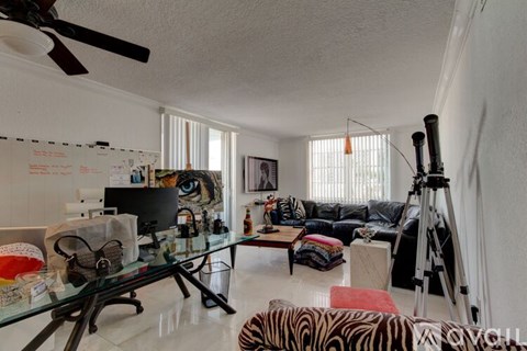 A living room with a glass table and a black and white zebra print chair.