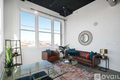 A living room with a glass table and a brown couch.