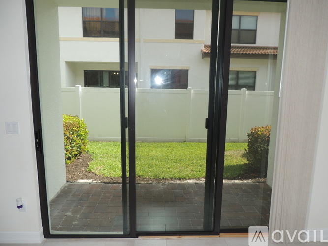A glass door with a black frame leads to a small garden area.