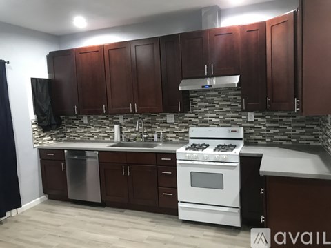 A kitchen with brown cabinets and a white stove top oven.