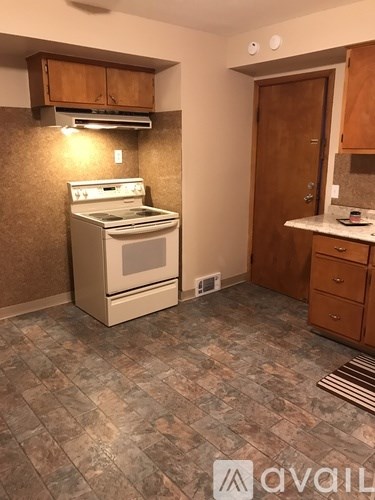 A kitchen with a stove top oven and a refrigerator.