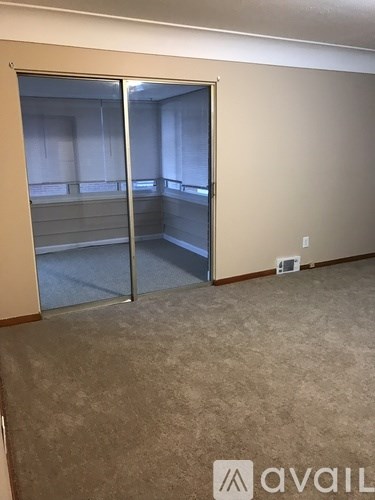 A room with a carpeted floor and a sliding door.