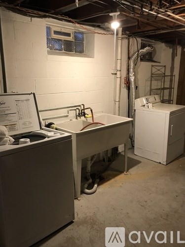 A dirty industrial room with a washing machine and a dryer.