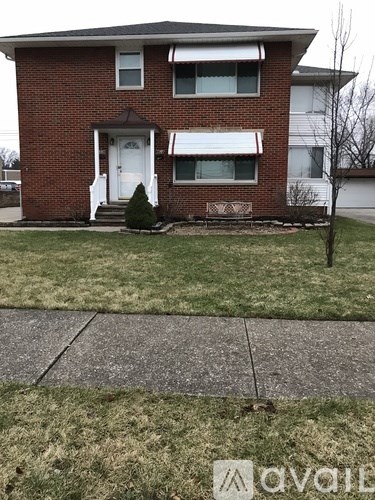 A brick house with a white door and windows.