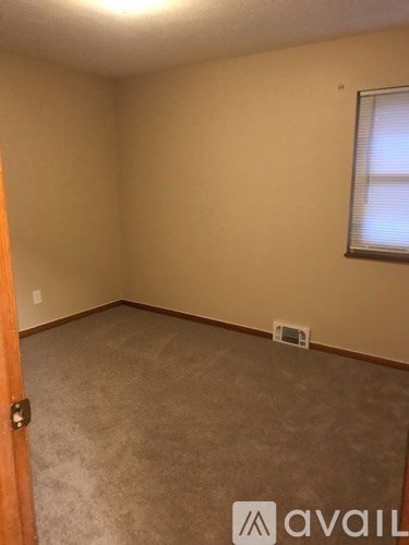 A room with beige walls and carpeted floor.