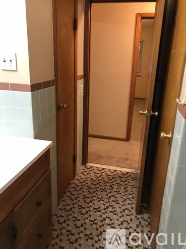 A bathroom with a tiled floor and a wooden door.