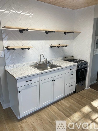 A kitchen with white cabinets and a marble countertop.