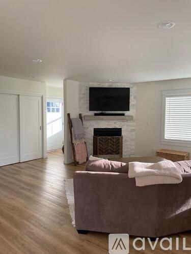 A living room with a grey couch and a fireplace.