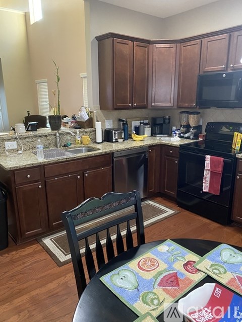 A kitchen with wooden cabinets and a black oven.