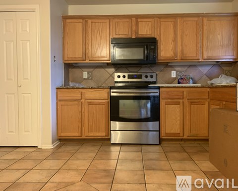 A kitchen with wooden cabinets and a black oven.