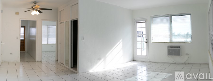 A spacious room with a ceiling fan and a window with blinds.