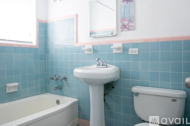 A bathroom with a white sink and a white bathtub.