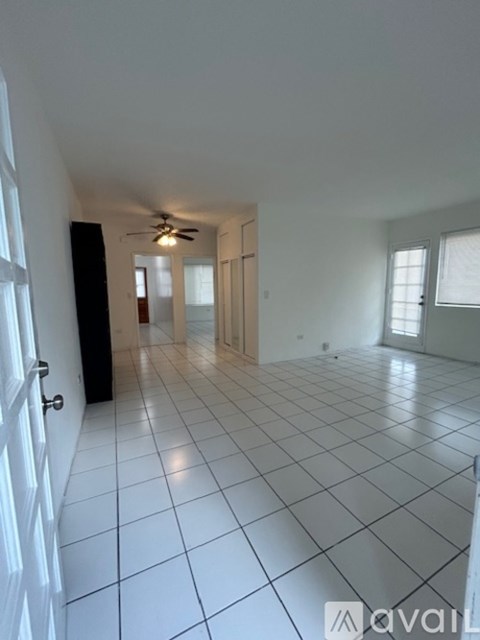 A room with white walls, a tiled floor, and a window with blinds.