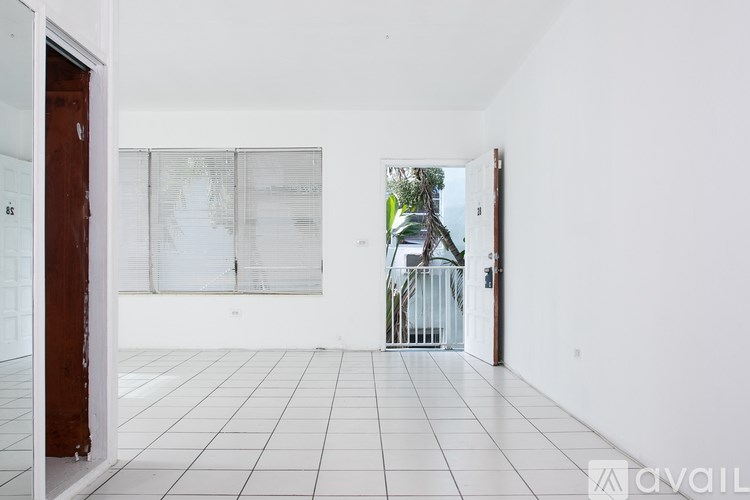 A white tiled room with a glass door leading outside.