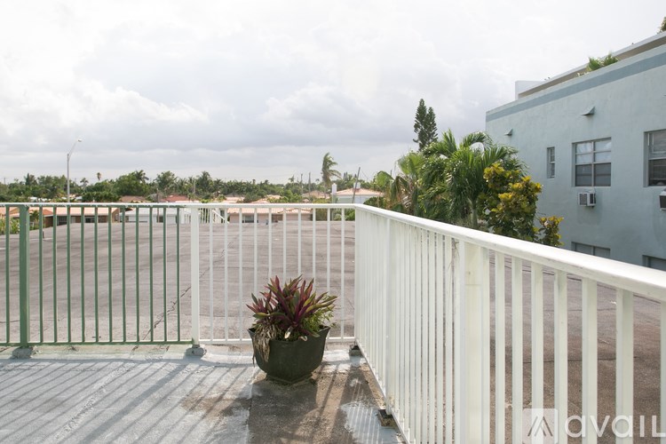 A balcony with a potted plant on a wooden table.
