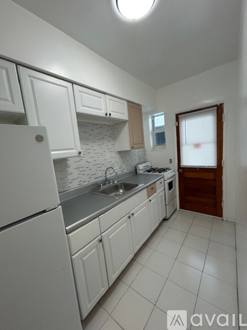 A white kitchen with a stove and sink.