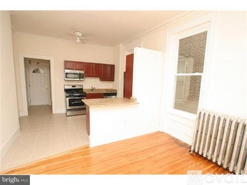 A kitchen with wooden floors and white walls.