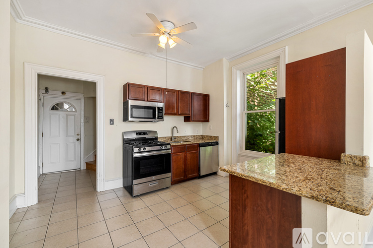 A kitchen with a refrigerator and wooden cabinets.