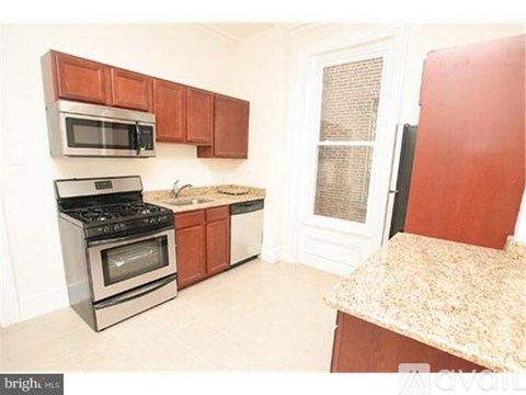 A kitchen with a stove, microwave, and cabinets.
