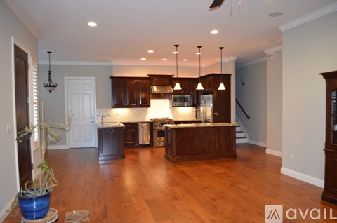 A kitchen with wooden cabinets and a large island with a sink.