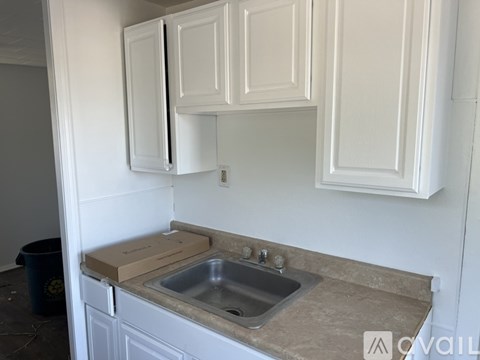 A kitchen with white cabinets and a granite countertop.