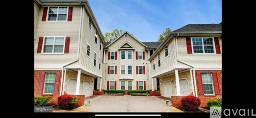 A large, two-story house with a red brick base and white walls.