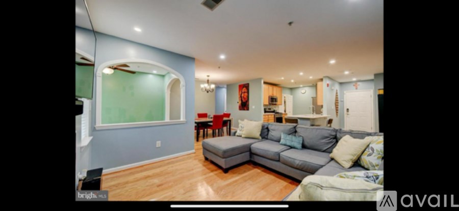 A living room with a grey couch and a blue wall.