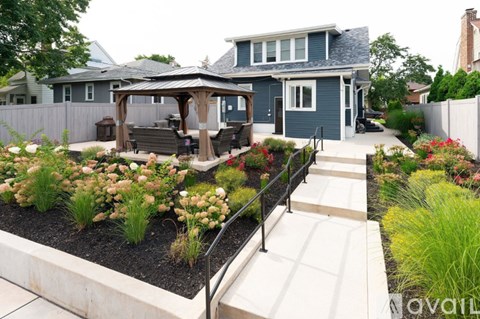 A backyard with a gazebo and a variety of plants.