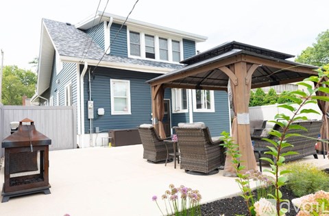 A house with a blue exterior and a covered patio area.