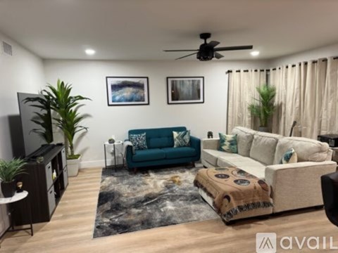 A living room with a blue couch and a rug.