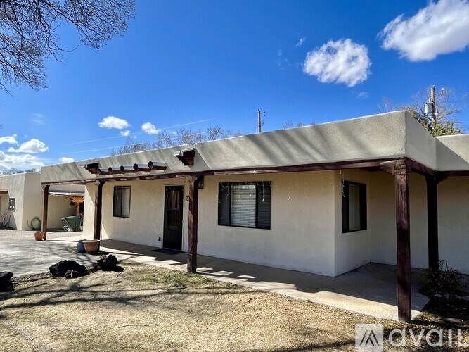 A house with a brown roof and a white wall with a brown door and windows.