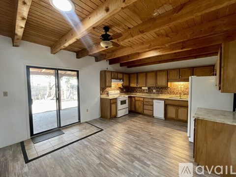 A kitchen with wooden cabinets and a ceiling fan.