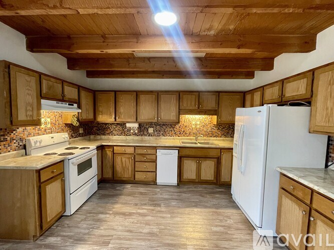 A kitchen with wooden cabinets and a white refrigerator.