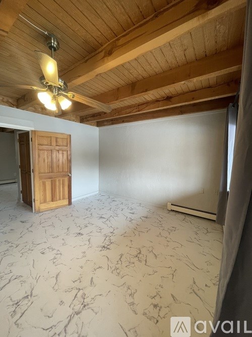 A room with wooden flooring and a ceiling fan.