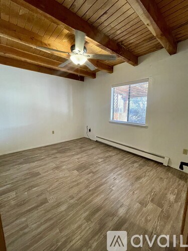 A room with wooden flooring and a ceiling fan.
