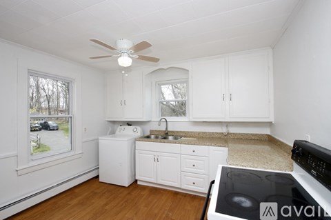A kitchen with white cabinets and a black stove top oven.