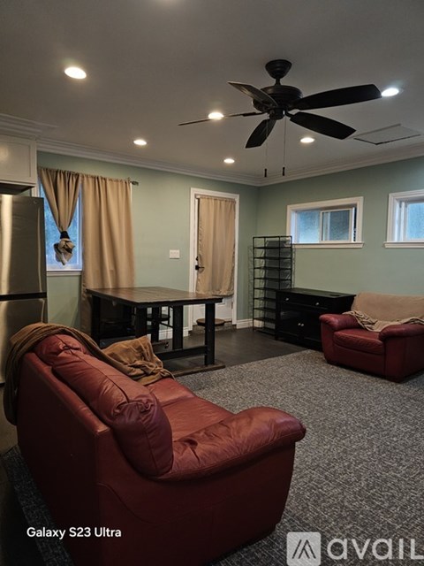 A living room with a red couch and a ceiling fan.